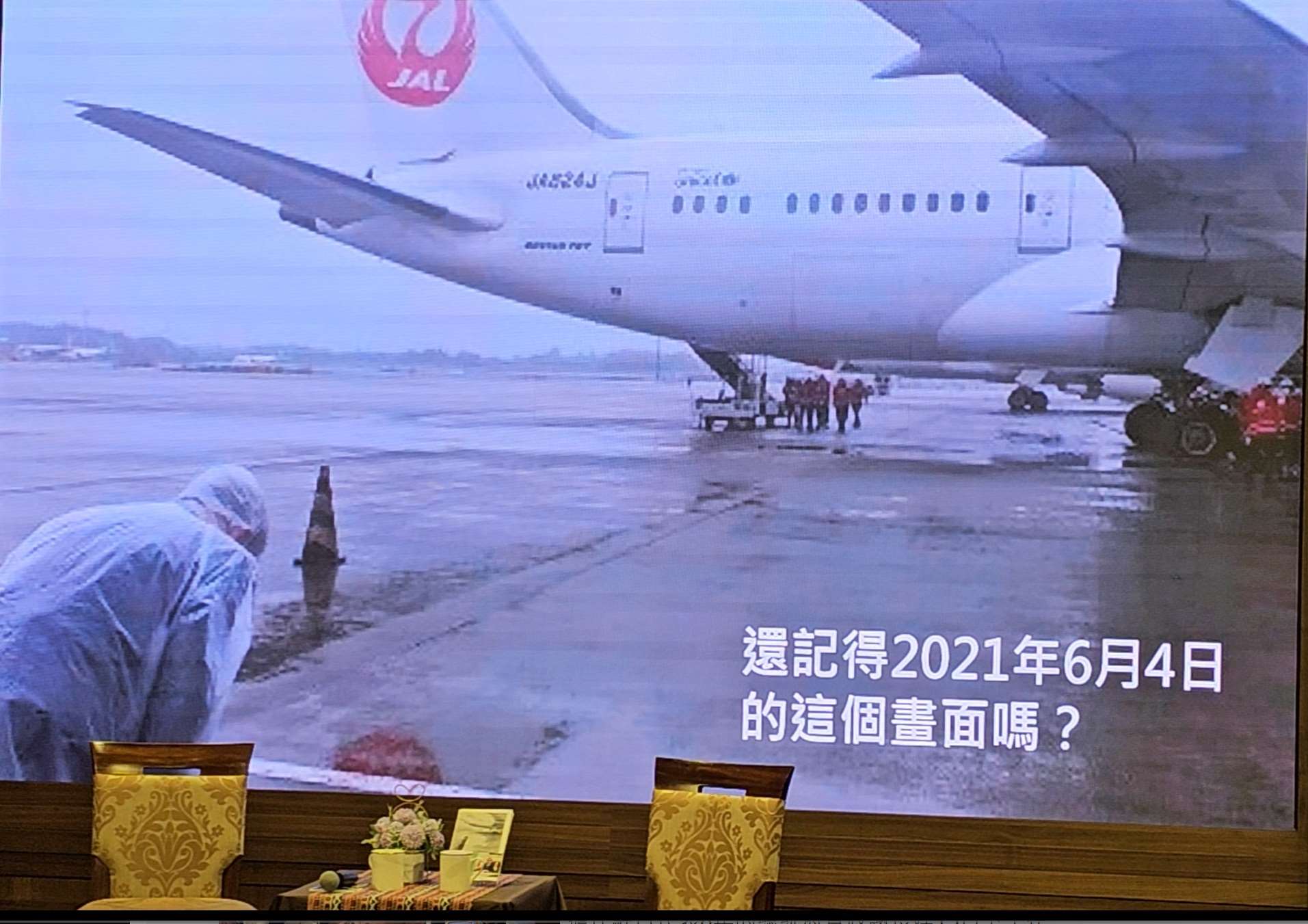 雨の中で、日本が無償供与した新型コロナウイルスワクチンを乗せた飛行機にお辞儀をする謝長廷・駐日代表(当時)。この一枚は多くの台湾人を感動させました。(写真:Rti王淑卿)