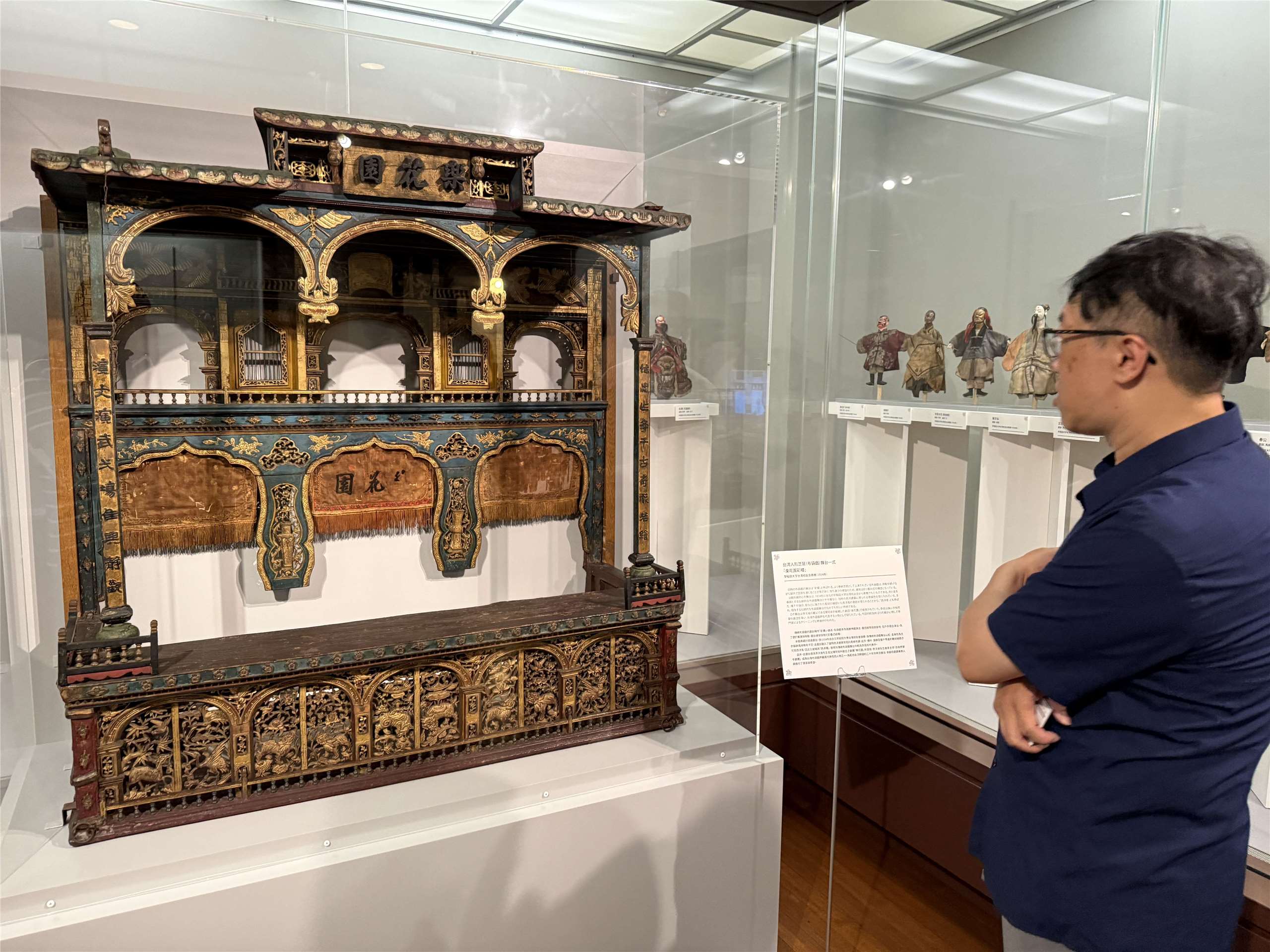 李俊寬仔細端詳李天祿年輕時表演的「樂花園」彩樓(鄭仲嵐攝影)