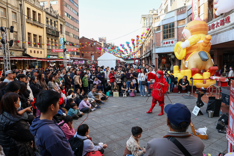 Ein Straßenkünstler sorgt am Neujahrsmarkt in der Dihuastraße für Unterhaltung (Foto: CNA)