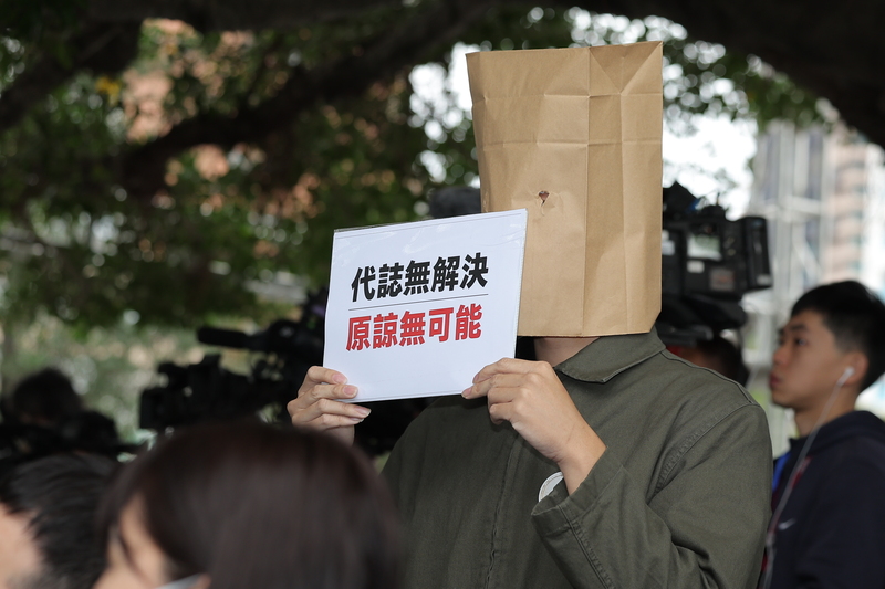 Während der Rede von Taipeis Bürgermeister Chiang Wan-an trug ein Angehöriger der Opfer eine Papiertüte über dem Kopf und hielt ein Schild mit der Aufschrift „Keine Lösung, keine Vergebung möglich“, um ihren Forderungen Ausdruck zu verleihen. (Foto: CNA)