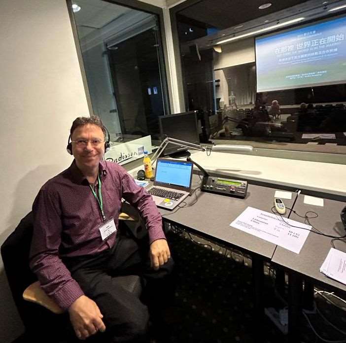 Günter im Einsatz in der typischen Dolmetscherkabine, hier eine Konferenz der WFTA (World Federation of Taiwanese Associations), 2023. (Foto: Günter Whittome)