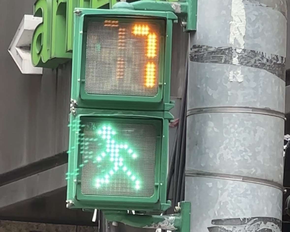 According to traffic signal regulations, the flashing "little green man" is to urge pedestrians already on the crosswalk to speed up, and not to signal they may begin crossing. (Photo: Tristan Hilderbrand)