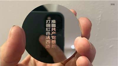 Chinese protestor uses project lens to cast anti-Communist slogans on a high-rise for 50 minutes.