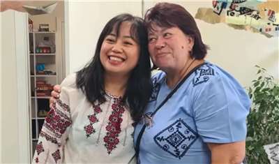 Ukrainian women receiving aid presented Wu Jing-yi (left), head of the humanitarian aid department of the International Cooperation and Development Fund (ICDF), with a traditional garment called a "vyshyvanka." (Photo courtesy of ICDF)
