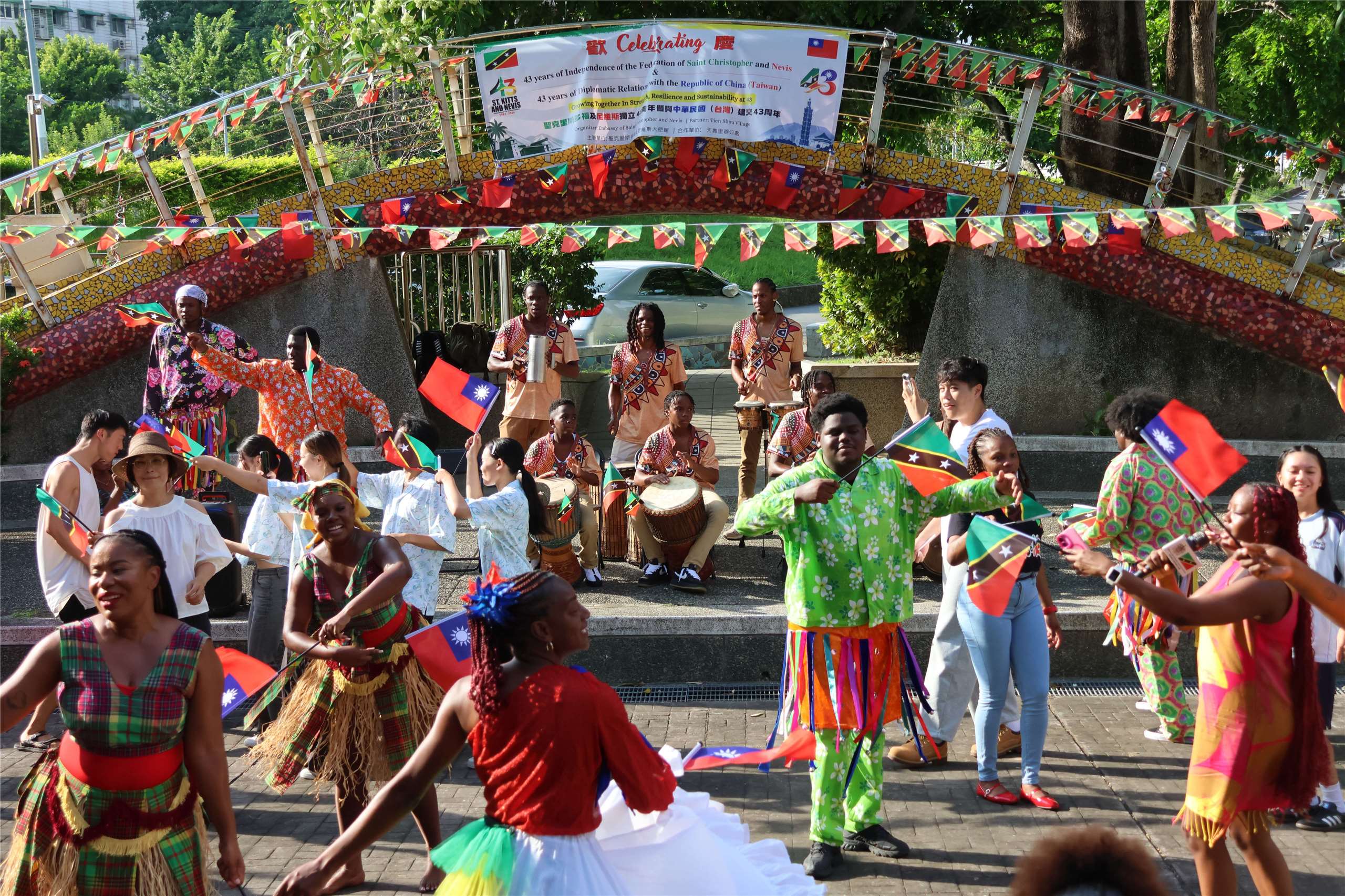 Performers and attendees dance and wave flags at a celebration marking 43 years of diplomatic relations between Taiwan and Saint Kitts and Nevis in Taipei on October 16, 2026. (Rti Photo/James Thompson)