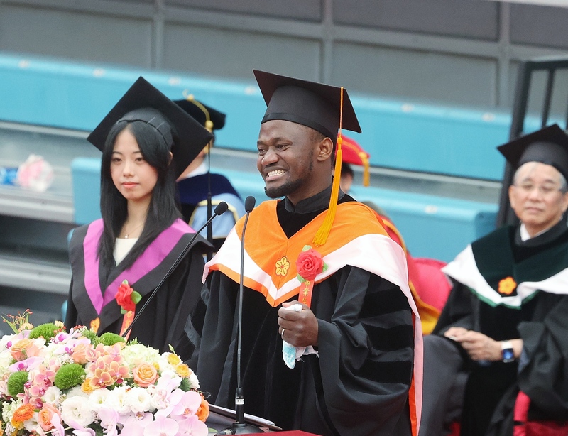 Nathan Thadeo Yoashi (front), an international student from Tanzania, speaks at National Taiwan University's graduation ceremony. (Photo: CNA)