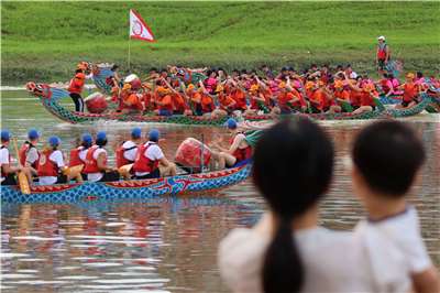 Spectators watch dragon boat teams, including one from the American Institute in Taiwan (AIT), participate in the Taipei International Dragon Boat Championships on June 19, 2026. (Rti photo/James Thompson)