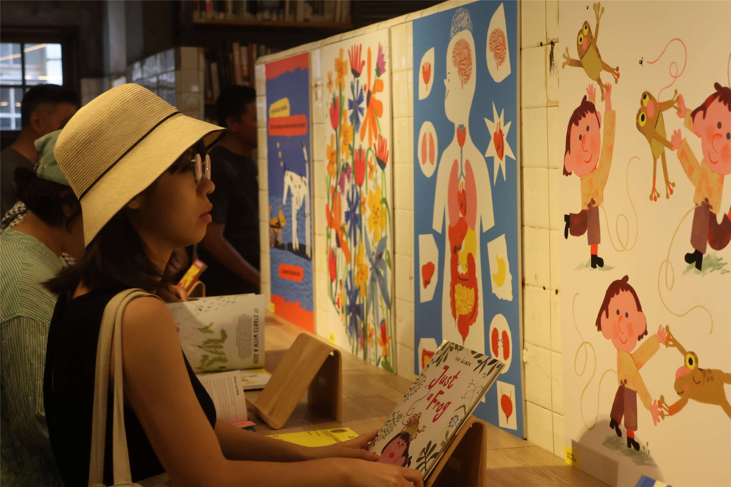 A visitor looks at artworks at the “Spotlight on Polish Illustration” exhibition preview in Taipei on July 13, 2026. (Rti Photo/James Thompson)