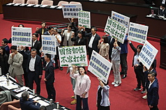 DPP legislators held up signs and chanted slogans to express their stance in the Legislature Friday, as both the ruling and opposition parties agreed to send party drafts of the drone procurement bills to legislative committees for review. (Photo: CNA)
