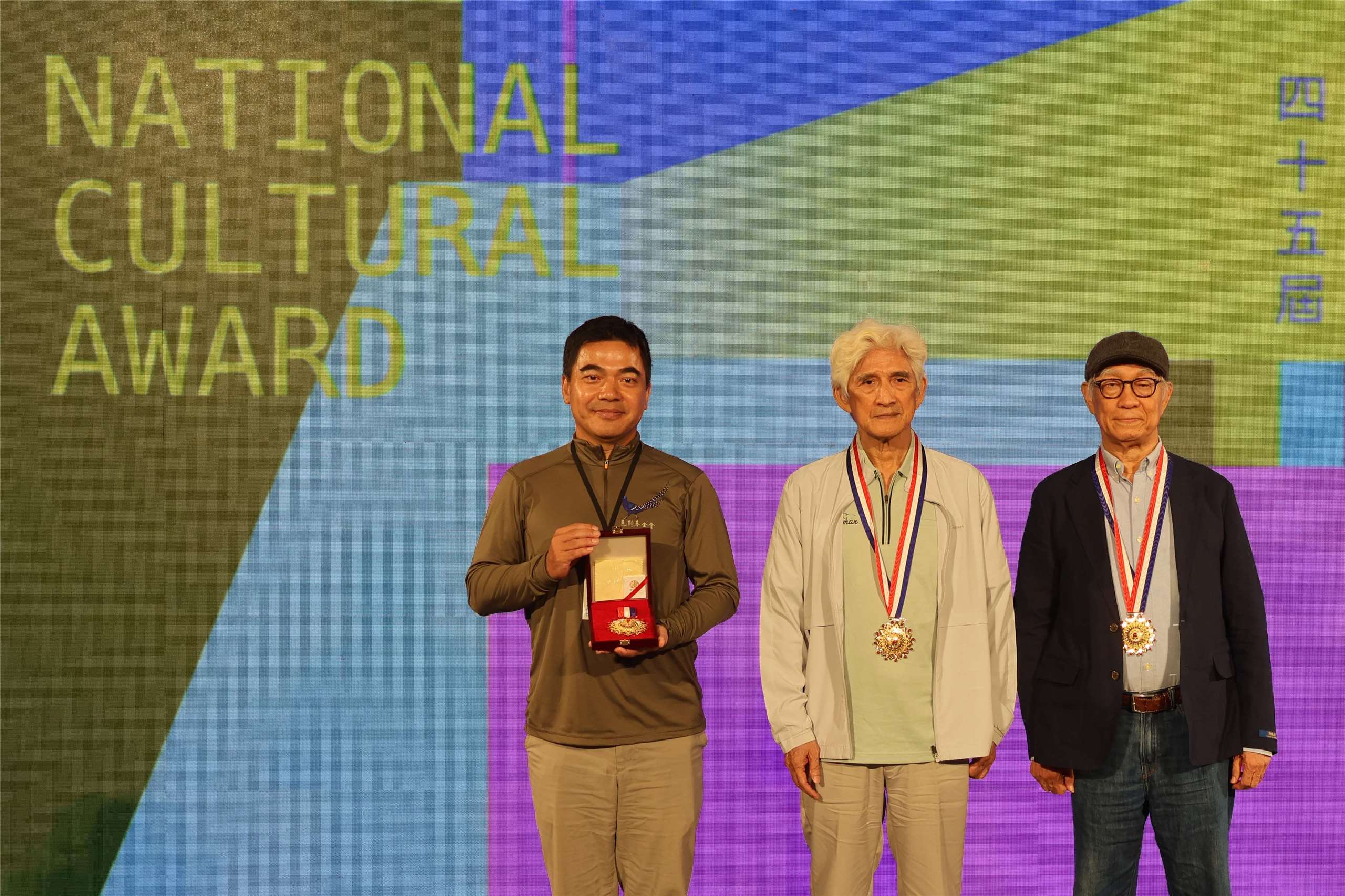 Left to right: Tuan Shih-tung, accepting an award on behalf of Hsu Jen-shiu, stands with award-winners Chiu Kun-liang and Liao Ching-sung at the 45th National Cultural Awards in Taipei on August 5, 2026. (Rti Photo/James Thompson)