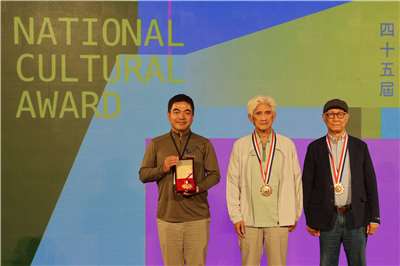 Left to right: Tuan Shih-tung, accepting an award on behalf of Hsu Jen-shiu, stands with award-winners Chiu Kun-liang and Liao Ching-sung at the 45th National Cultural Awards in Taipei on August 5, 2026. (Rti Photo/James Thompson)
