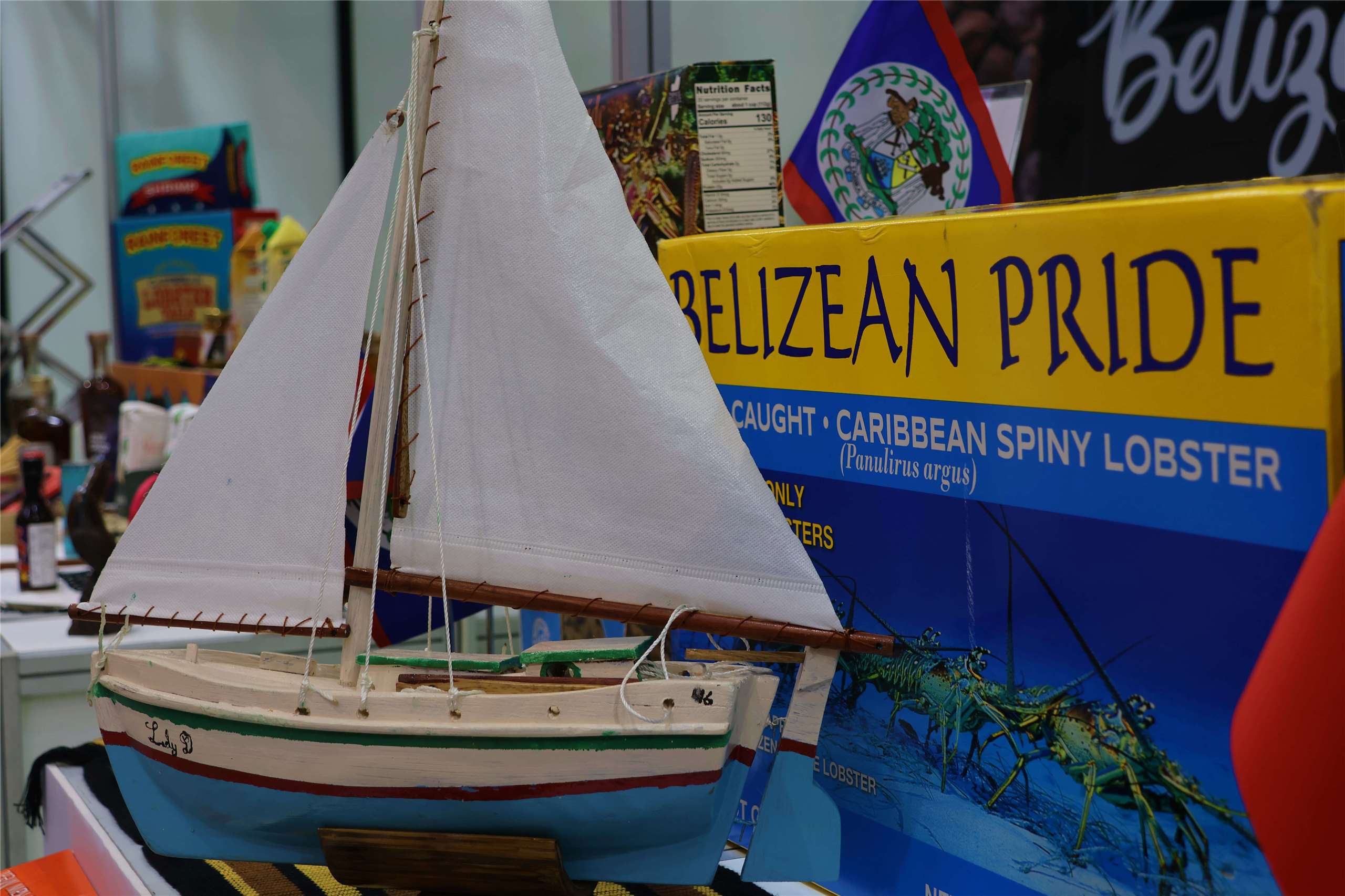 A model sailboat is displayed beside Belizean lobster products at the Food Taipei Mega Shows 2026 Belize exhibition area in Taipei on June 24, 2026. (Rti Photo/James Thompson)