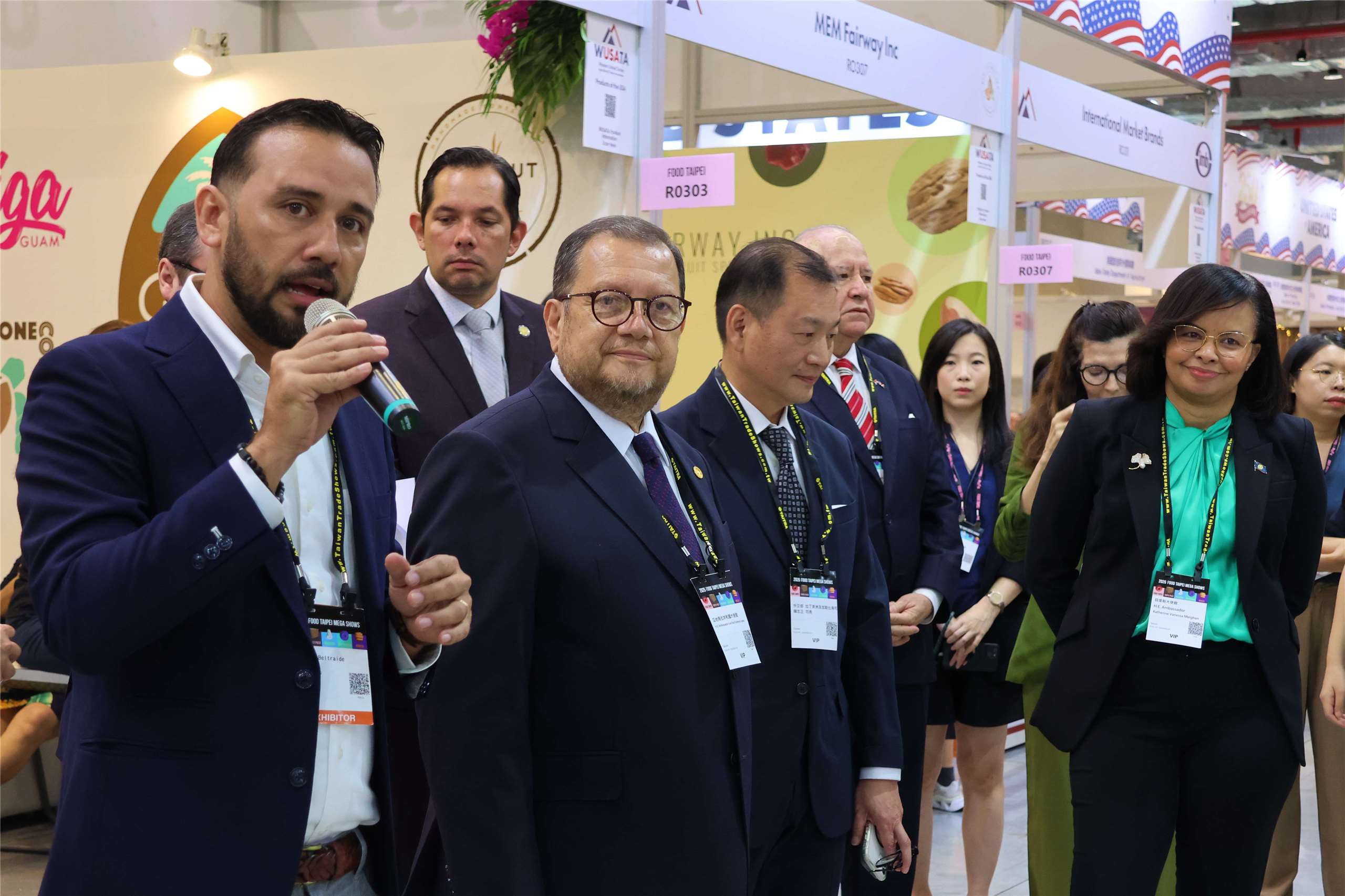 Beltraide senior advisor Omar Castillo, holding a microphone, introduces the Food Taipei Mega Shows 2026 Belize exhibition area to ambassadors and other officials in Taipei on June 24, 2026. (Rti Photo/James Thompson)