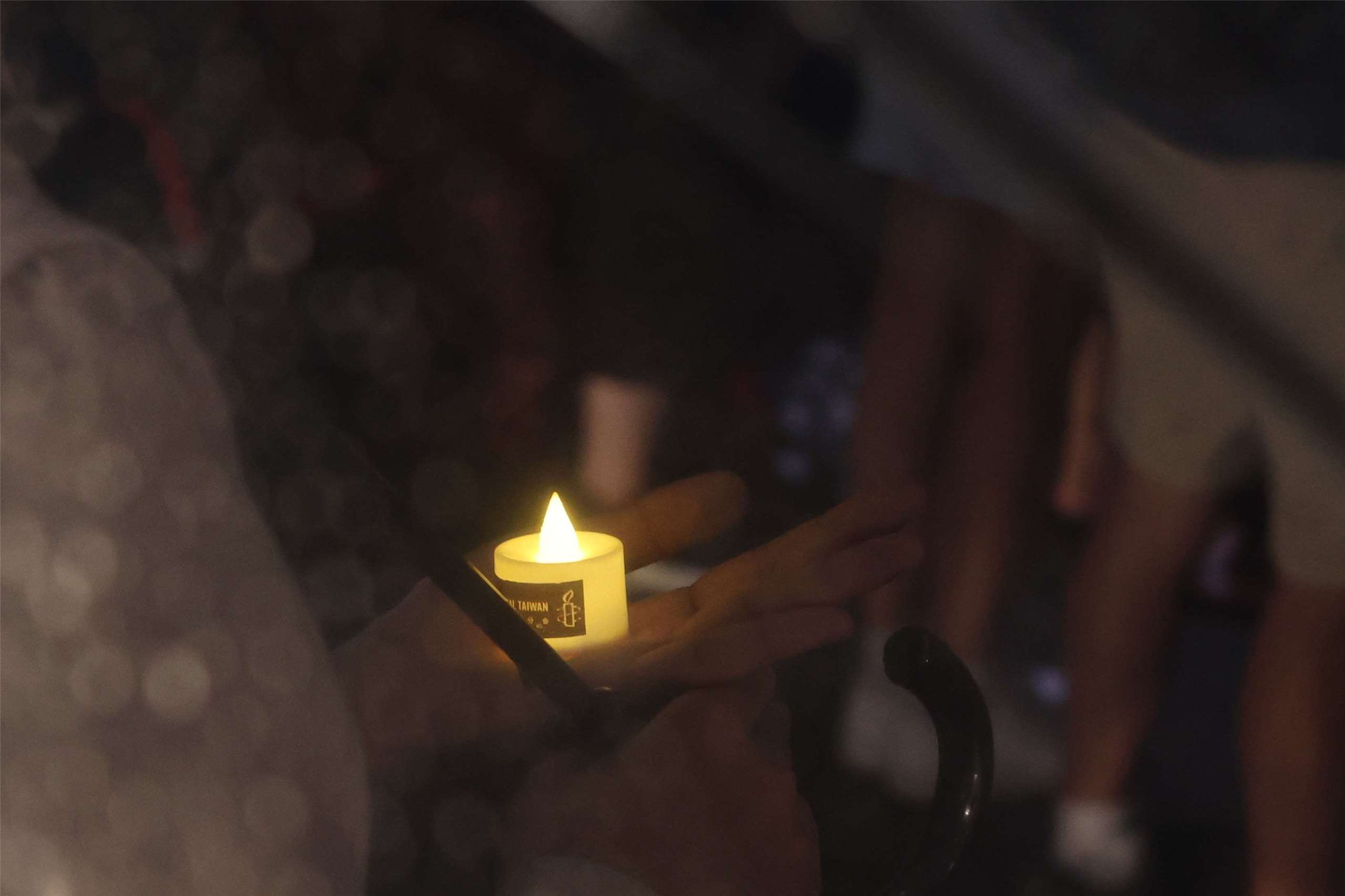 An attendee holds an electronic candle in Liberty Square in Taipei during a vigil marking the 37th anniversary of the Tiananmen Square Massacre. (Rti Photo/James Thompson)