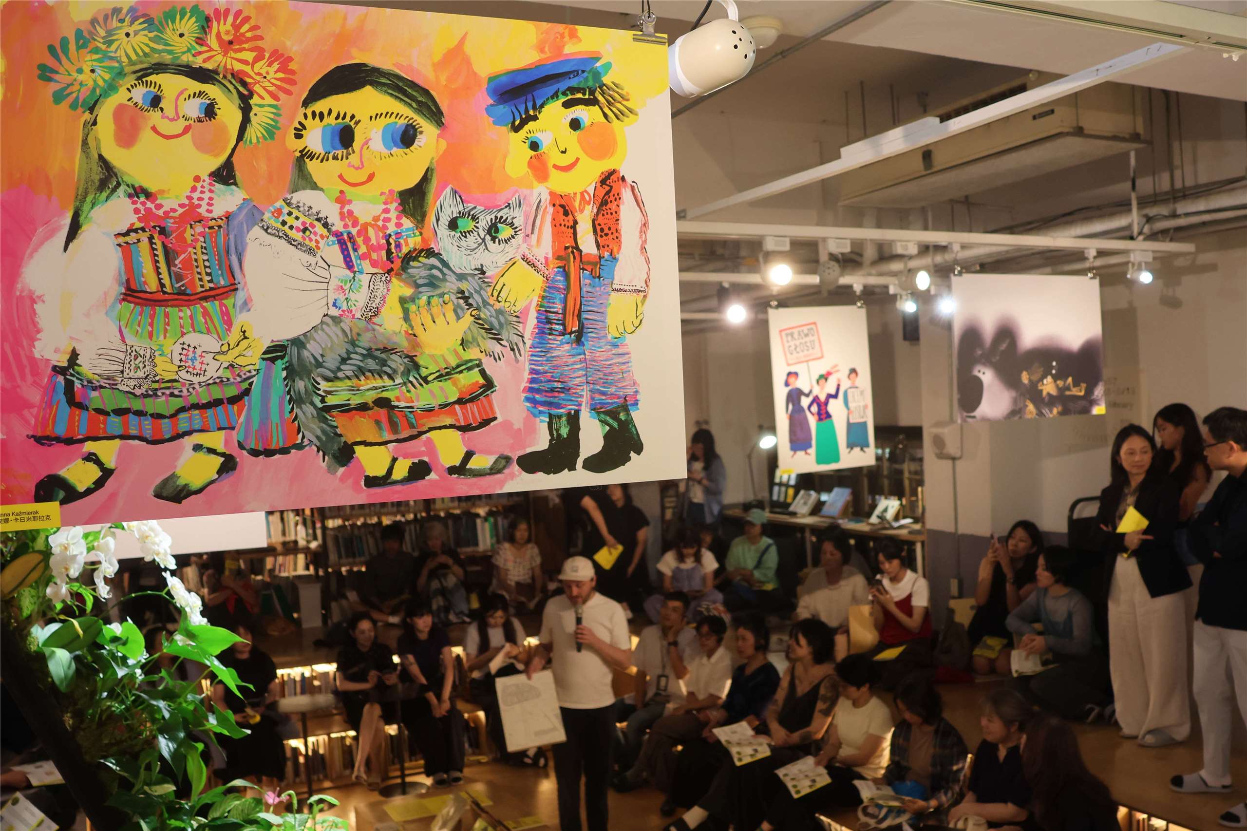 An illustration by Polish artist Anna Kaźmierak hangs above visitors during a preview of the “Spotlight on Polish Illustration” exhibition in Taipei on July 13, 2026. (Rti Photo/James Thompson)