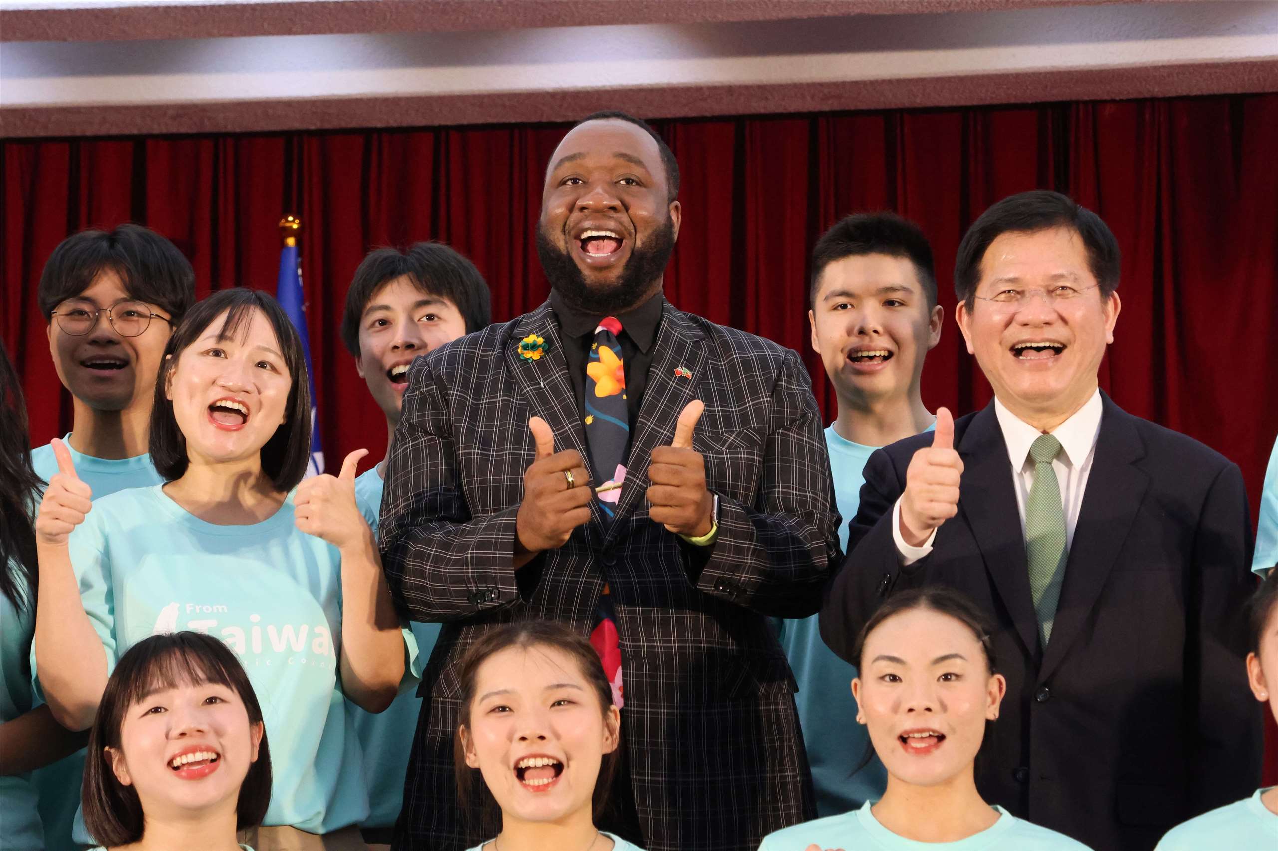 Taiwan ICDF Deputy Secretary General Hsieh Pei-fen, Saint Kitts and Nevis Ambassador to Taiwan Donya L. Francis, and Foreign Minister Lin Chia-lung pose with participants at a send-off ceremony for youth ambassadors in Taipei on August 12, 2026. (Rti Photo/James Thompson)