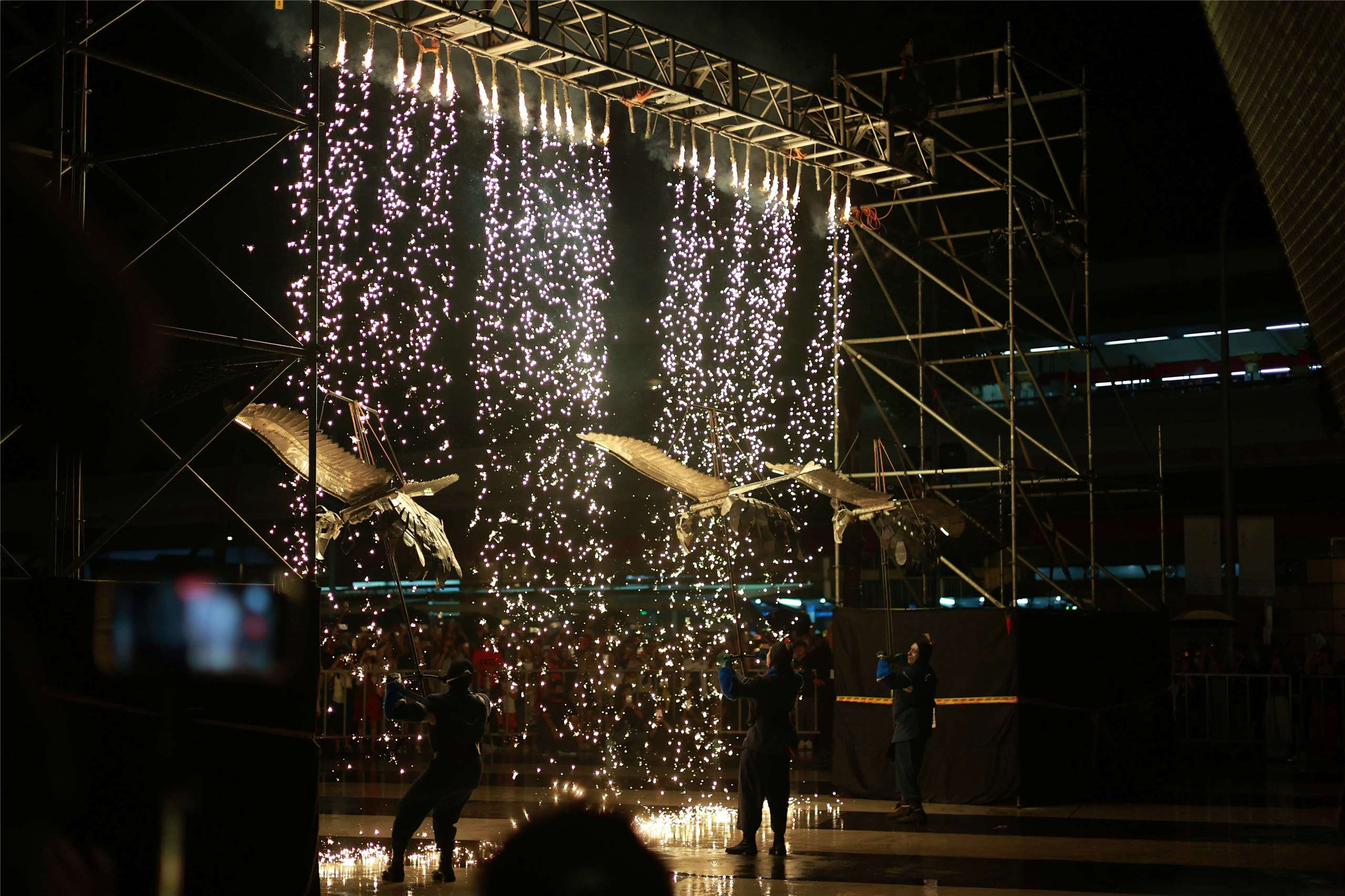 Performers operate large bird models beneath a shower of sparks during “The Elephants Are Coming” in Taipei on September 6, 2026. (Rti Photo/James Thompson)