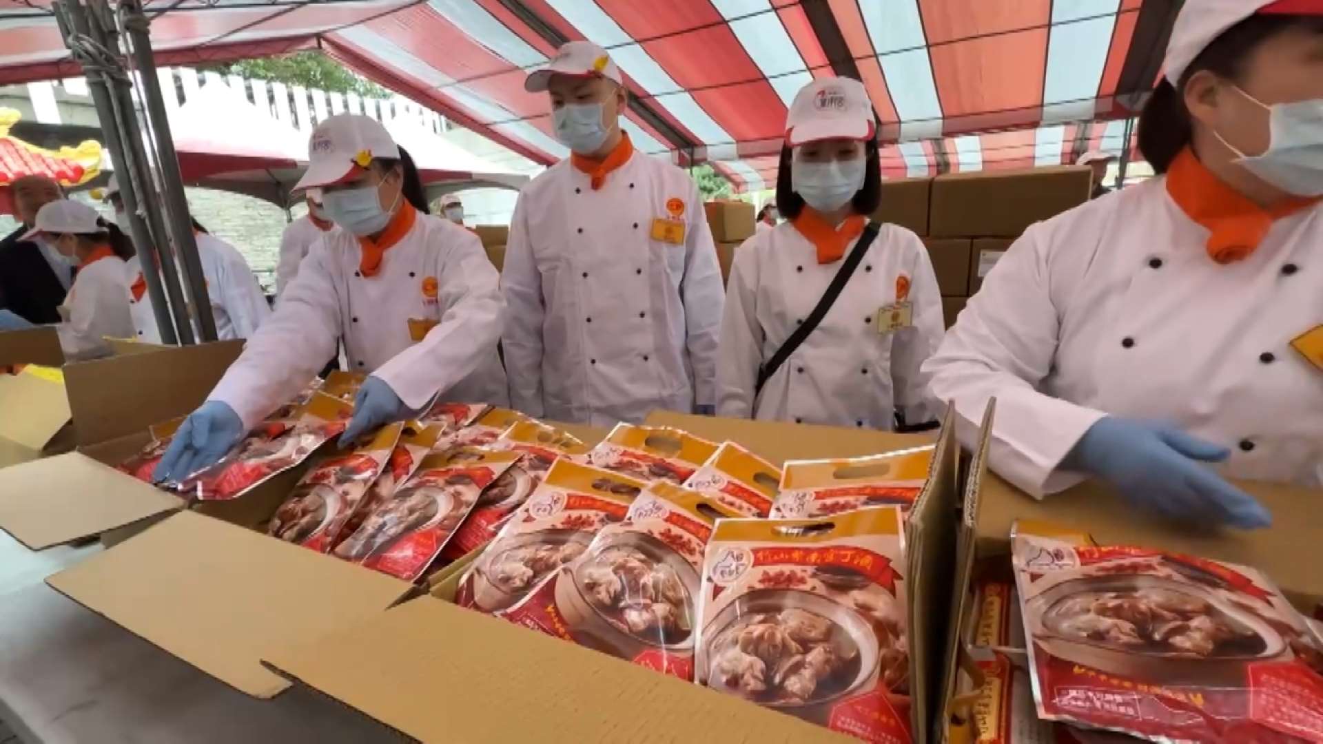 Reparto de paquetes de pollo con sésamo al vino de arroz (vino ding) en el templo de Zinan de Nantou, en el centro de Taiwán (Foto: captura de vídeo)