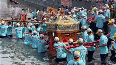 Fieles llevando palanquines de los Dioses Invitados en el canal de Xinwen, Chiayi (Foto: captura de vídeo)