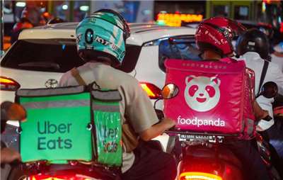 Repartidores en moto de Uber Eats y Foodpanda (Foto: CNA)