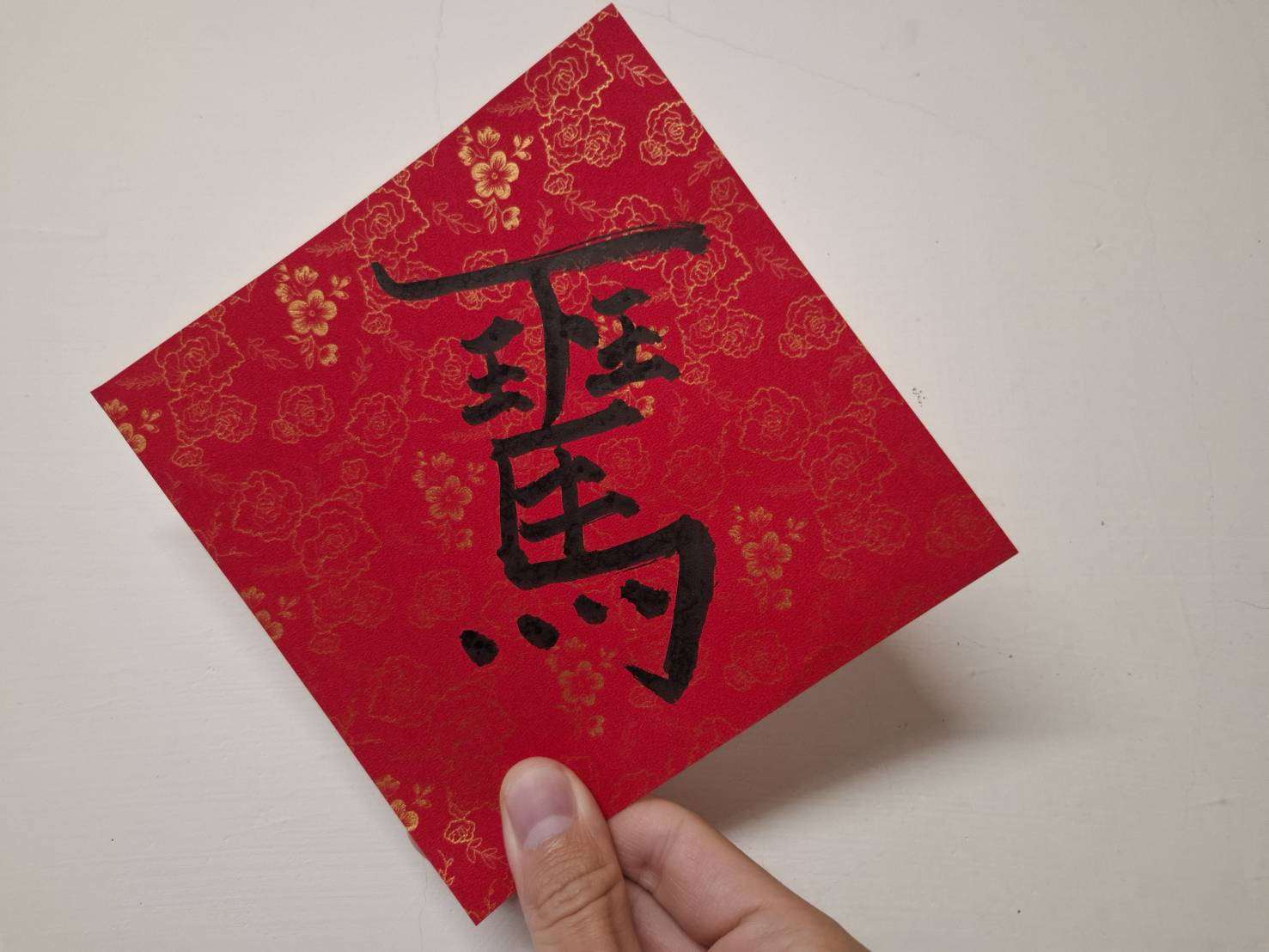 Creativa copla de primavera de un carácter compuesto escrito sobre papel cuadrangular. Dice “terminar la jornada laboral montado a caballo (de inmediato)” (馬上下班). (Foto: Rti)