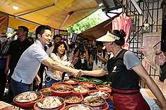 Une marchande de poisson salue le maire de Taipei, qui passe dans le marché pour soutenir une députée faisant face à un vote de destitution (photo CNA)
