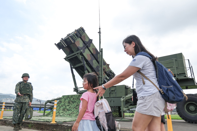Une mère et ses enfants passent devant des militaires à Taipei
