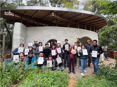 Photo finale du cours de design en permaculture 2024 par Tammy Turner à l'Association d'éducation à l'agriculture urbaine de Taichung, devant la Maison Goutte, construction en terre, chaux et bambou (photo : FB de 臺中市食農教育發展協會)