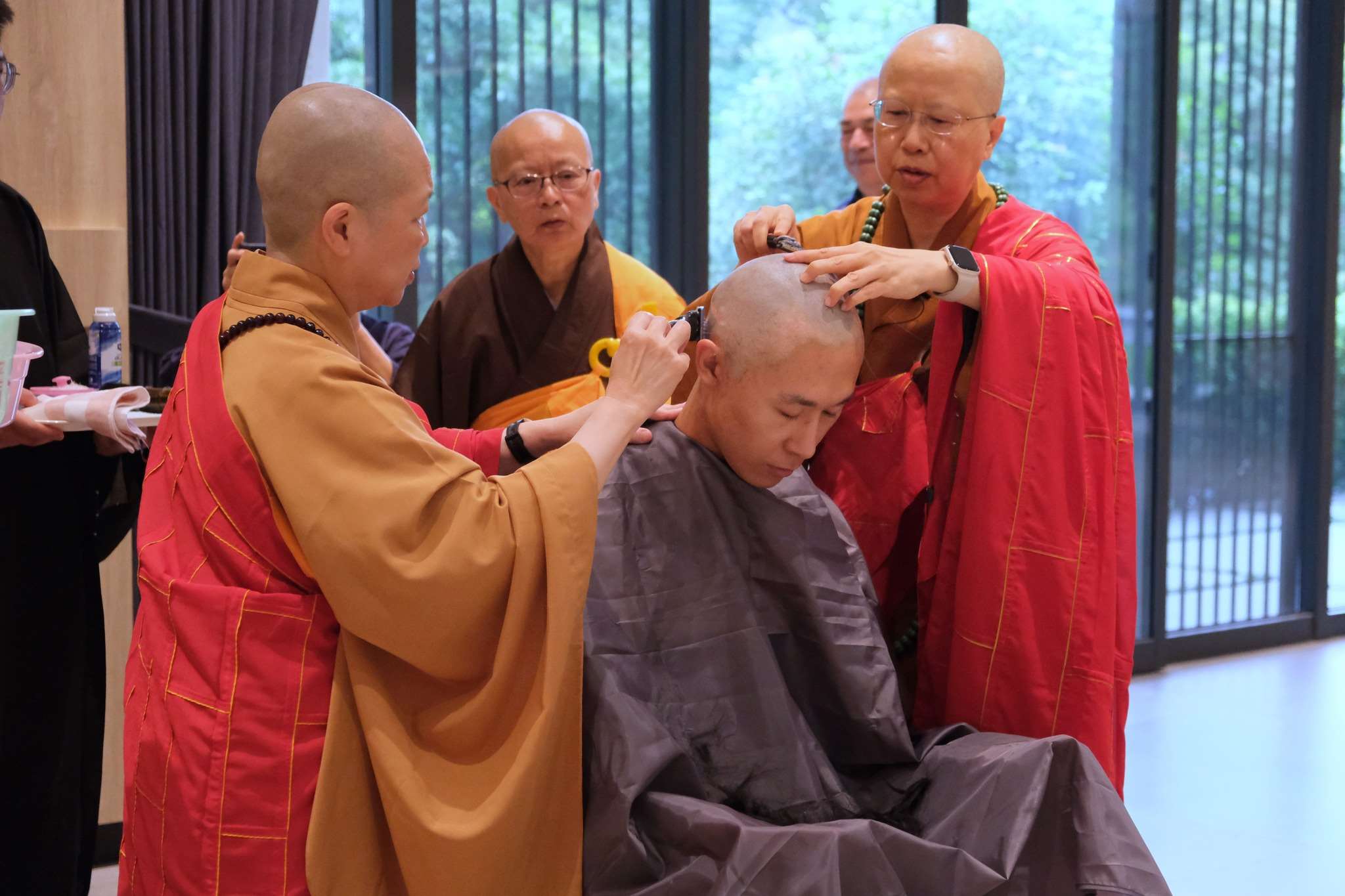 La Vénérable Chao-hwei et deux autres nonnes donnent la tonsure et l'ordination à un jeune moine, en mai 2025 (photo : Facebook 釋昭慧)