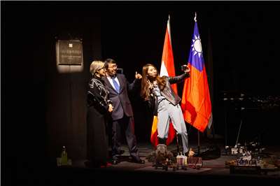 Les trois protagonistes de la pièce Ceci n'est pas une ambassade faisant un selfie devant la plaque de l'ambassade éphémère de Taïwan (photo fournie par Vidy, Claudia Ndebele)