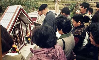 Cérémonie des 40 jours après le décès d'un autochtone Kavalan, dans la commune de Xinshe, sur la côte est de Taïwan, dans un cimetière chrétien. Au premier plan, le Père André Bareigts (photo : Liu Pi-chen)