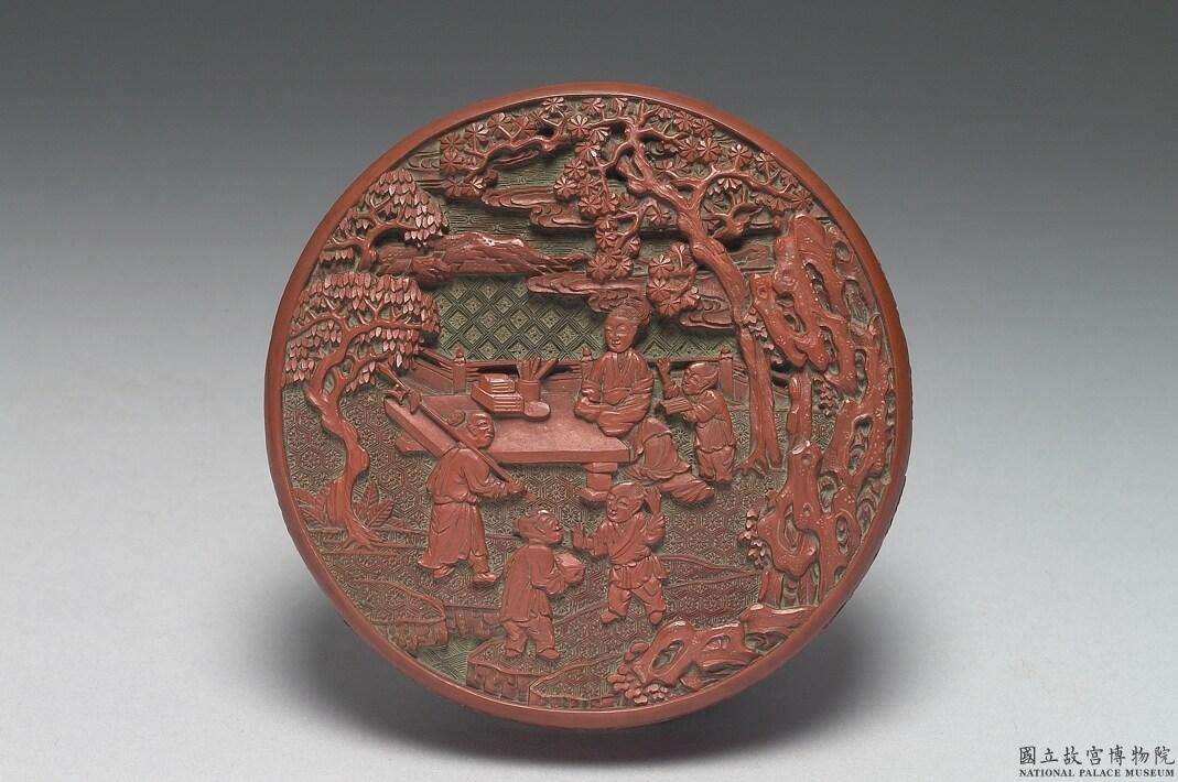 Image 3: Boîte ronde à trois niveaux en laque rouge sculptée est décorée d'une scène d'enseignement aux enfants (source MNP)