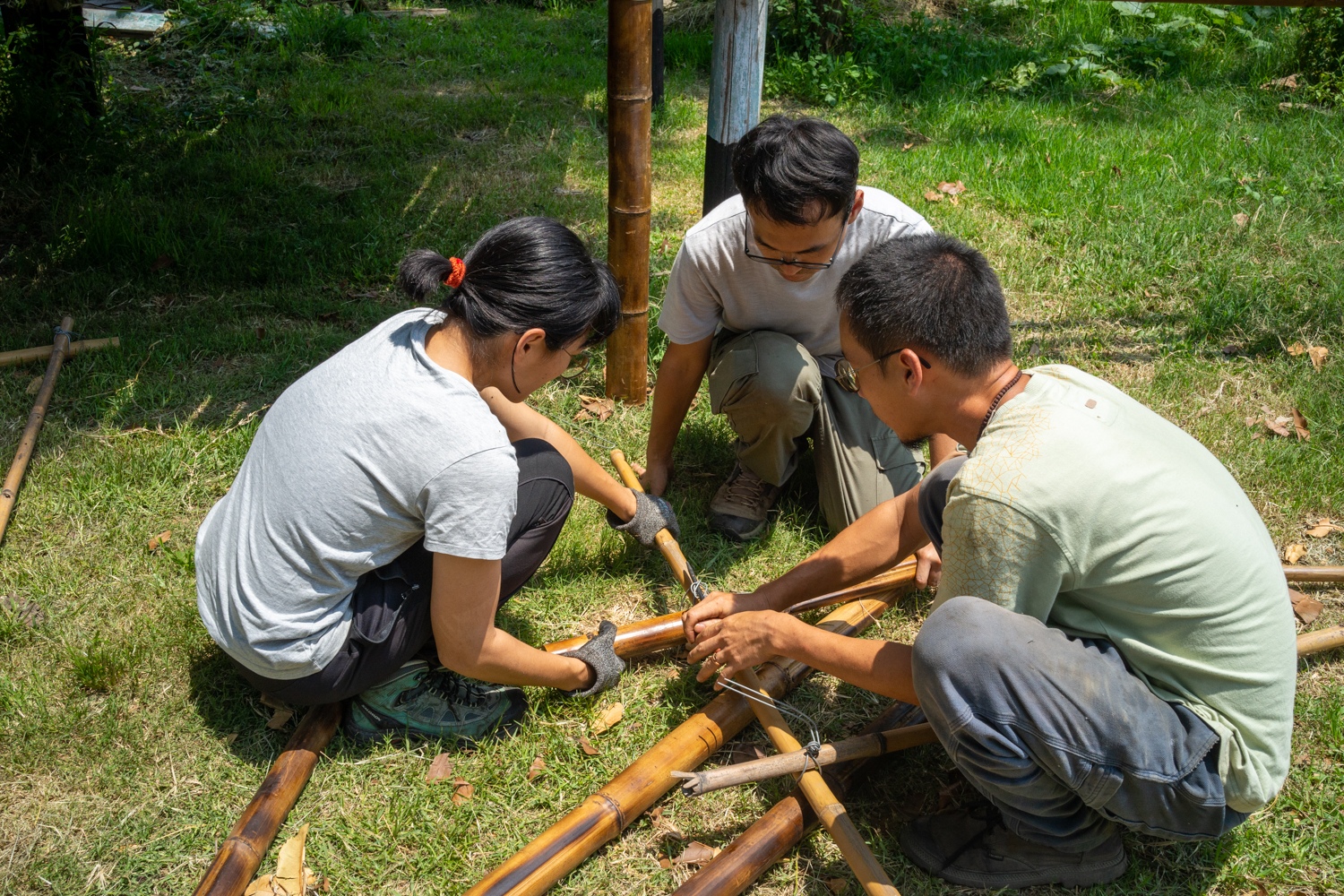 Les participants au mouvement du jardin terrestre apprennent à faire des noeuds en fil de fer pour la construction de la cabane en bambou (photo : Sasa)