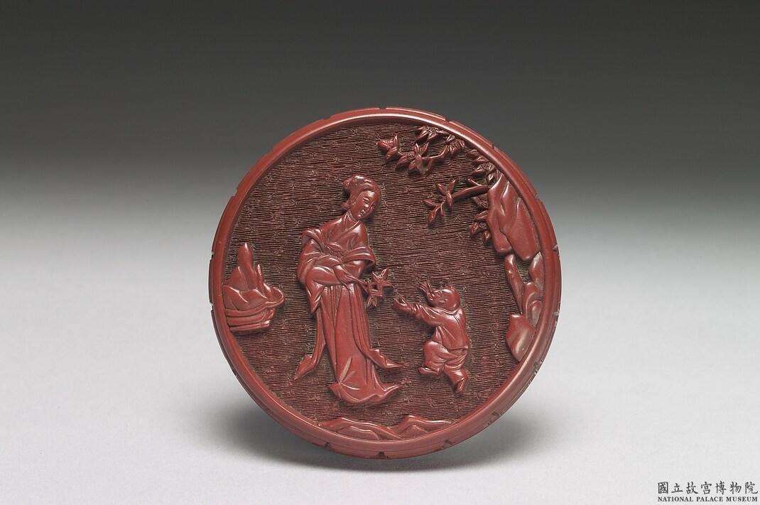 Image 2: Boîte en laque rouge sculptée décorée avec une dame et un enfant en train de jouer (source MNP)