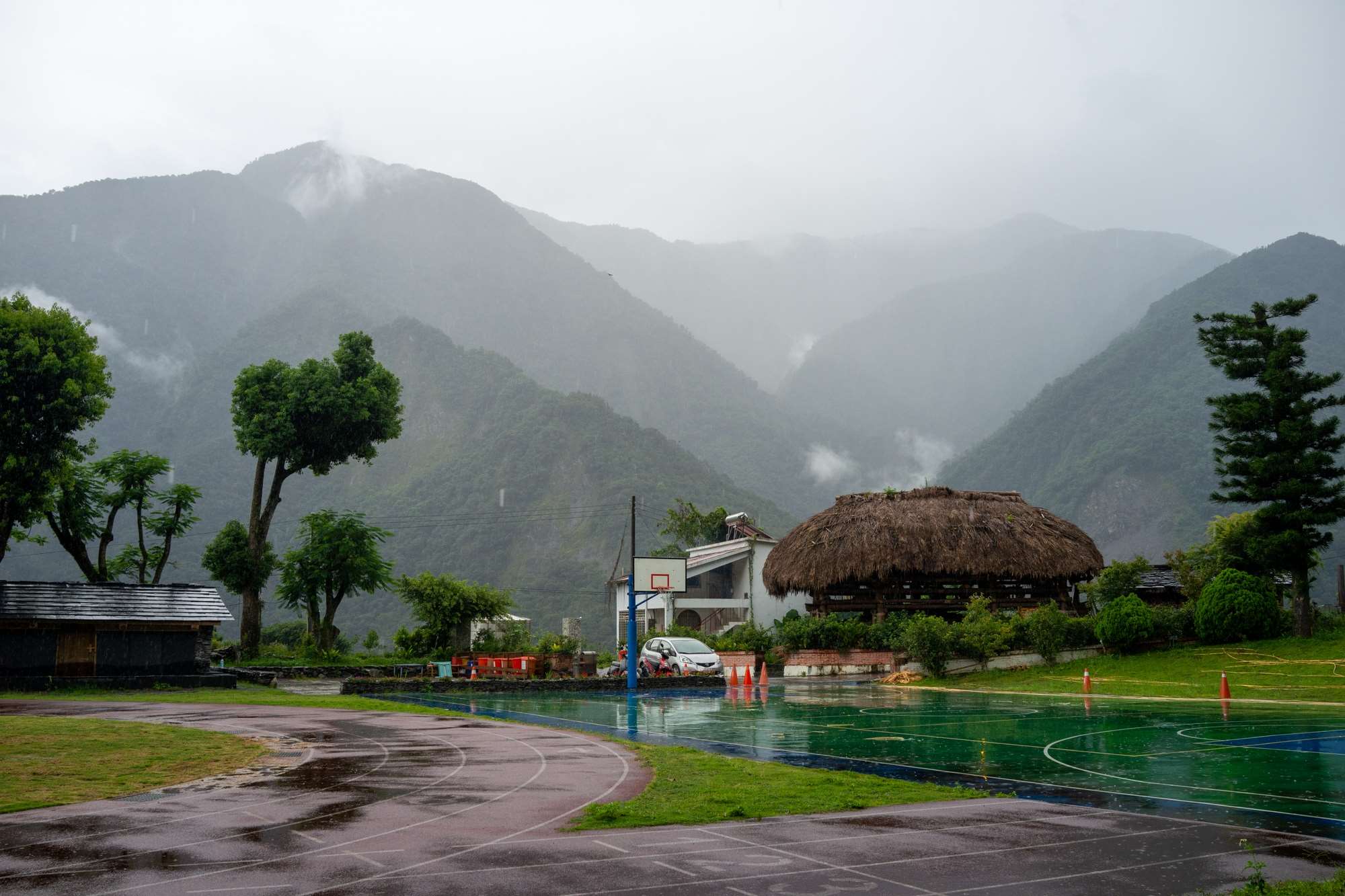 Le Hufu, construction traditionnelle Tsou, à côté de constructions Bunun dans la cour de l'école de Jiumei, dans le comté de Nantou (photo : Sasa)