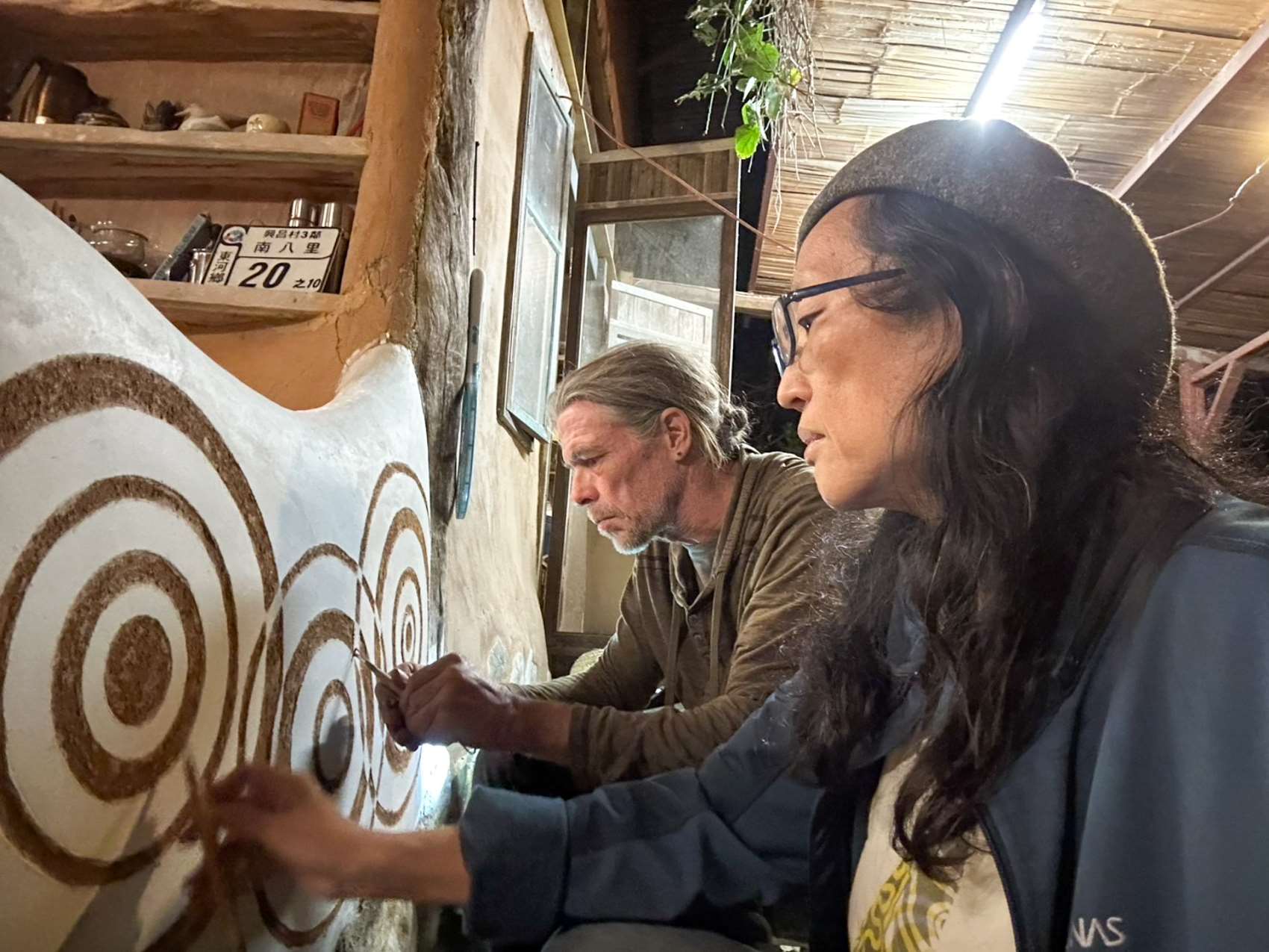 Peter et Hui-yi, co-fondateurs du centre de formation en permaculture Earth Passengers, en train de réaliser un sgrafitto (photo : Sasa) 