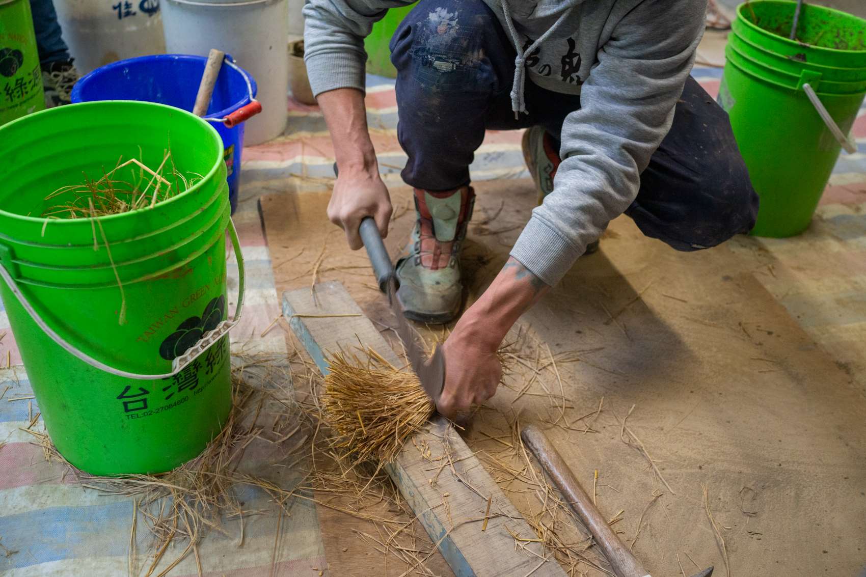 Faute d'avoir le temps de laisser fermenter l'enduit d'accrochage pendant trois mois, nous avons frappé sur la paille pour ouvrir les fibres (photo : Sasa) 