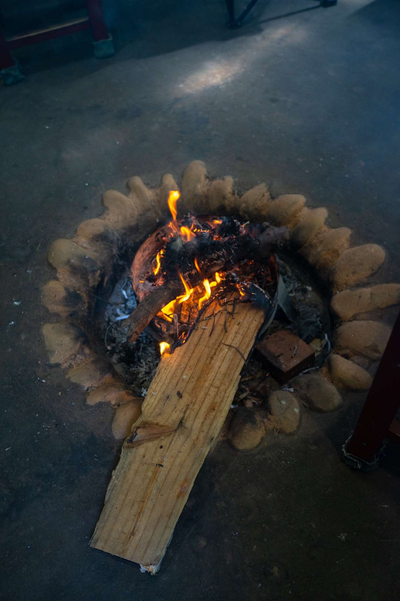 En hiver, on fait un feu pour se réchauffer, en été pour que la fumée chasse les moustiques ! Allumer un feu régulièrement est aussi très important pour protéger le bambou du plafond (traité au borax) par fumigation (photo : Sasa)