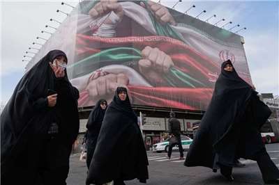 Keterangan foto: sekelompok wanita Iran berjalan melewati papan reklame besar di Teheran (foto: AP)