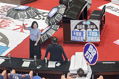 民進党団の呉思瑤・幹事長は「立法委員は法を犯していなければ、立法院が休会となることを恐れない、国民党と台湾民衆党は、9月まで途切れないよう会期を延長することで、立法委員の特権を使い、司法の調査を妨害しようとしているのではないか」と批判、立法院では皮肉をこめ、「庇護」を意味する傘を指すパフォーマンスをみせた。　(写真：CNA)
