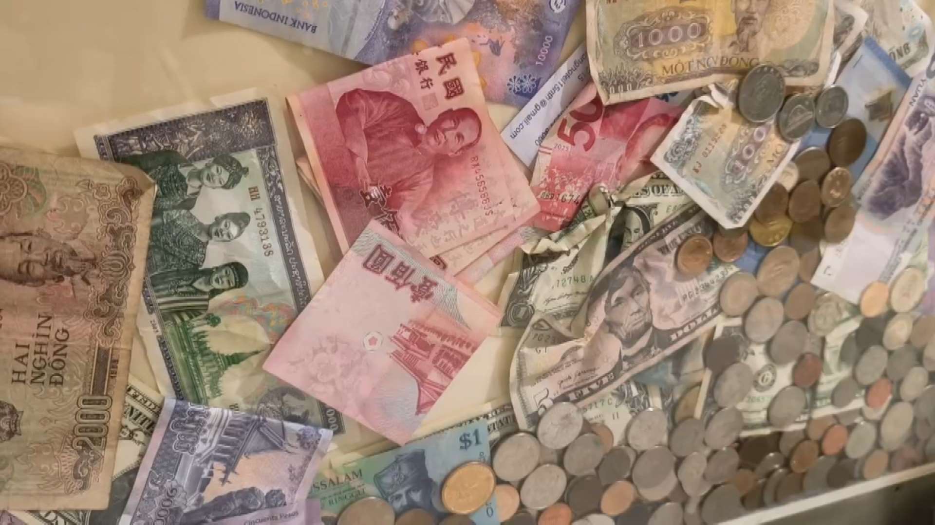 桃園国際空港にある充電スポットの透明なアクリル板の中に、多くの紙幣や硬貨が入れられている。まるで願い事の池のようで、通りかかる旅客の目を引いている。（写真：RTI）