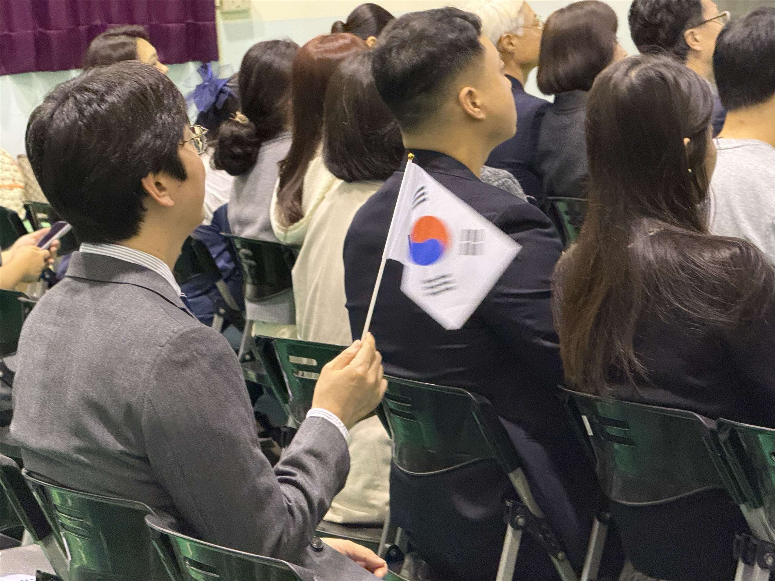 중화민국타이완한인회 주최로 ‘제107주년 삼일절 기념식’이 3월1일 오전 타이베이 한국학교 대강당에서 거행되었다. 참석자가 대회 진행 중에 자리에서 태극기를 흔드는 모습.  -사진: jennifer pai백조미
