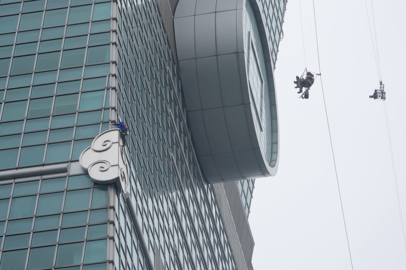Pendaki tebing bebas terkenal Amerika Syarikat, Alex Honnold, akan melakukan pendakian solo tanpa perlindungan ke atas bangunan Taipei 101 pada 24 haribulan waktu Taiwan, dan acara ini akan disiarkan secara langsung ke seluruh dunia oleh Netflix. Gambar menunjukkan Honnold (kiri) menjalani pendakian percubaan dalam keadaan hujan pada pagi 21 haribulan, sementara pasukan penggambaran dokumentari merakam aksi tersebut dari udara pada ketinggian tinggi. Sumber:CNA