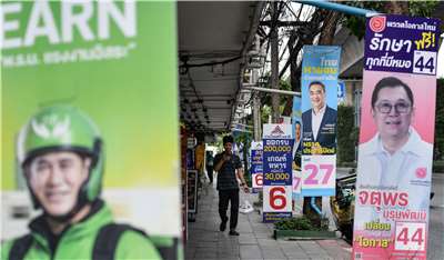 Thailand hari ini (8hb) mengadakan pilihan raya umum bagi memilih anggota parlimen. Di ibu kota Bangkok, orang ramai dilihat berjalan di laluan pejalan kaki yang dipenuhi papan iklan calon pilihan raya. (AFP)
