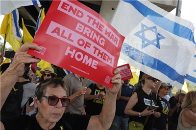 Humahawak ng mga plakard at bandila ng Israel ang mga nagpoprotesta sa isang kilos-protesta na inorganisa ng mga pamilya ng mga bihag na Israeli. Ang mga bihag ay hawak sa Gaza Strip mula Oktubre 2023, at nananawagan ang kanilang mga pamilya ng agarang aksyon upang matiyak ang kanilang pagpapalaya, pati na rin ng tigil-putukan sa digmaan laban sa Hamas. Ginawa ang protesta noong Agosto 26 sa Tel Aviv. Photo from AFP.