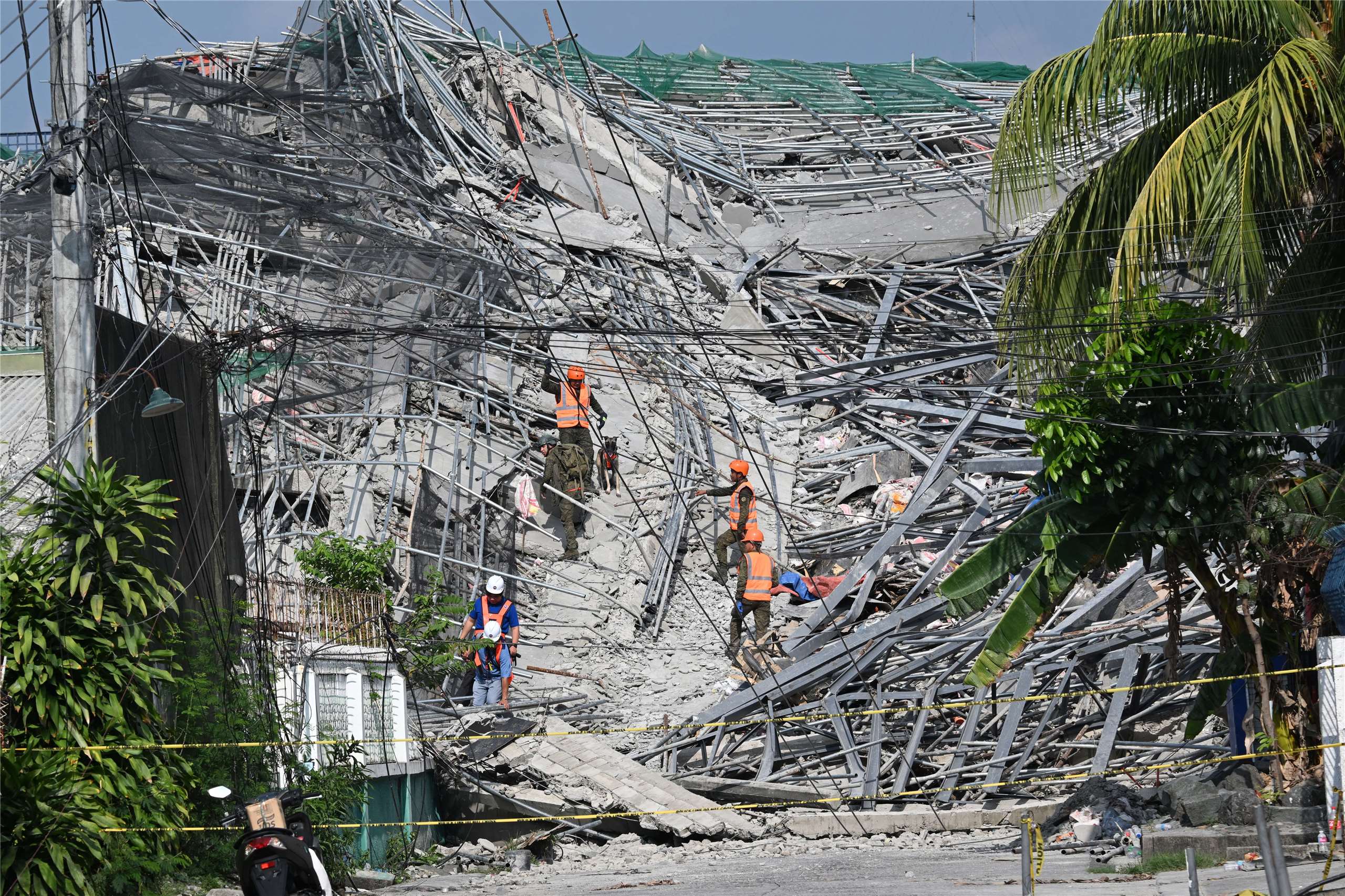Gumuho noong ika-25 ang isang gusaling itinatayo malapit sa Maynila sa Pilipinas, na ikinamatay ng 3 katao habang 17 pa ang nananatiling nawawala. Nasa larawan ang mga local rescue personnel habang nagsasagawa ng search and rescue operation. (Photo: AFP)