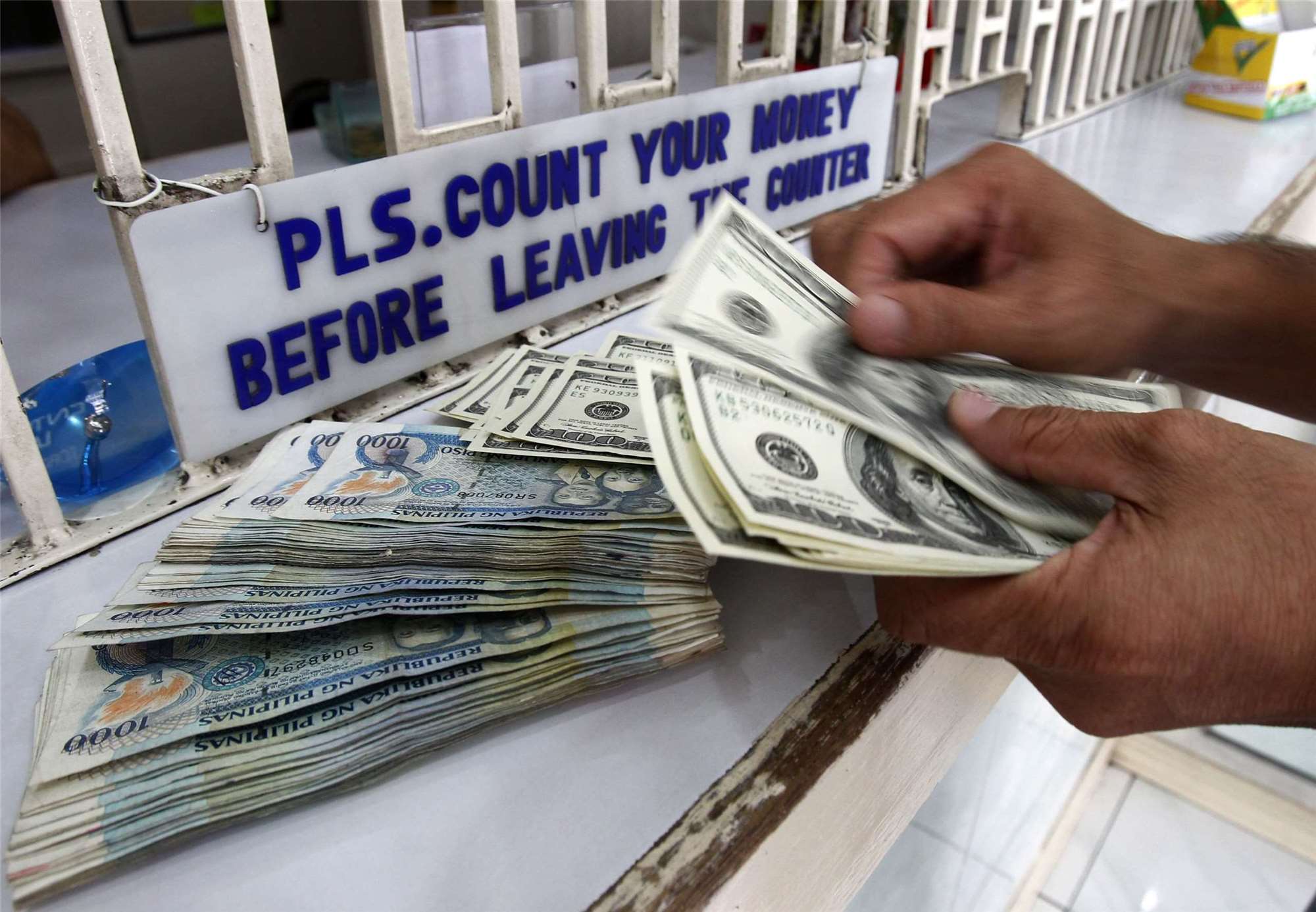 Nagbabala ang Philippine economic officials at business sector na kung magpapatuloy ang paghina ng piso, tataas ang cost ng imported fuel at raw materials, at sa huli ay maaaring humina ang purchasing power ng mga mamamayan. Makikita sa larawan ang isang worker na nagbibilang ng US dollars at Philippine pesos sa isang money changer sa Manila, Philippines. Photo Source: Reuters / Dazhi Images