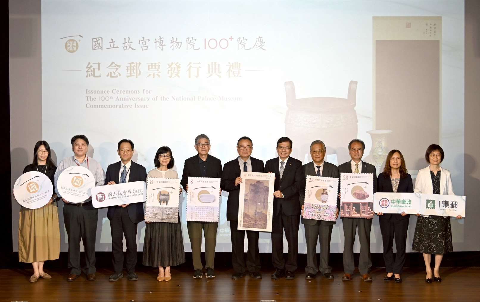 國立故宮博物院100﹢院慶紀念郵票揭幕儀式，貴賓持手拿牌大合照。(中華郵政提供)