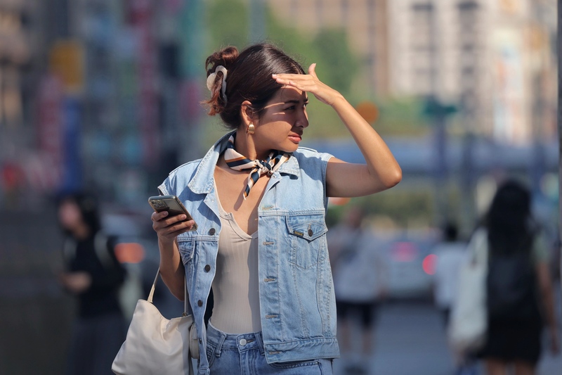 全台各地天氣炎熱高溫，圖為台北市中正區街頭民眾以手遮擋刺眼陽光。(資料照片)

