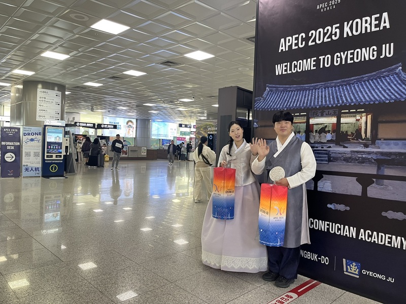 韓國釜山金海國際機場大廳可看到多名穿著韓國傳統服飾的迎賓人員，手提APEC字樣的燈籠。